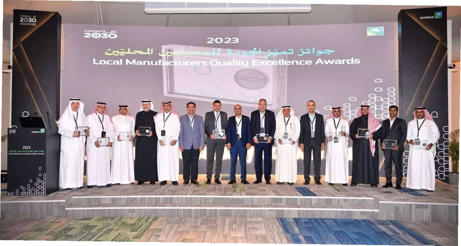 Group of executives holding awards at a corporate event, celebrating local manufacturing excellence.