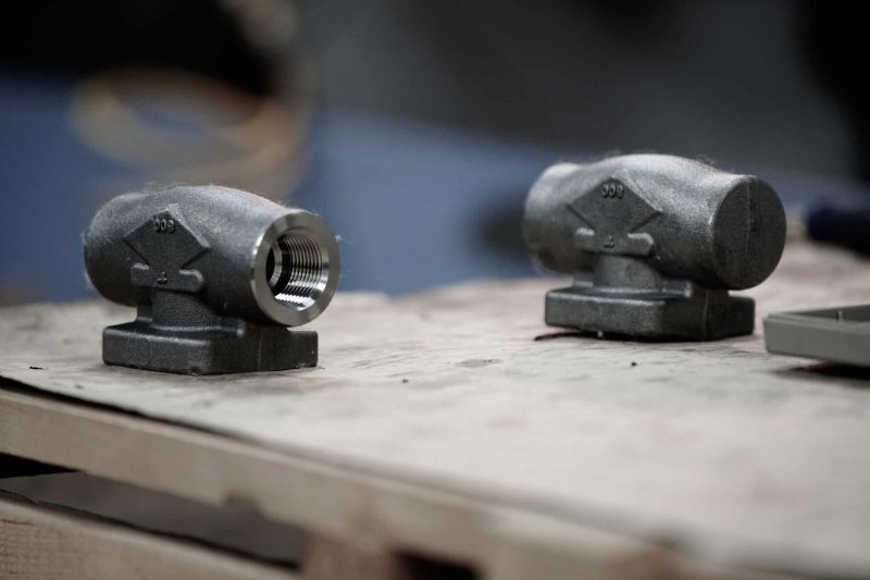 1 Precision industrial valves on wooden workbench for manufacturing and plumbing applications.
